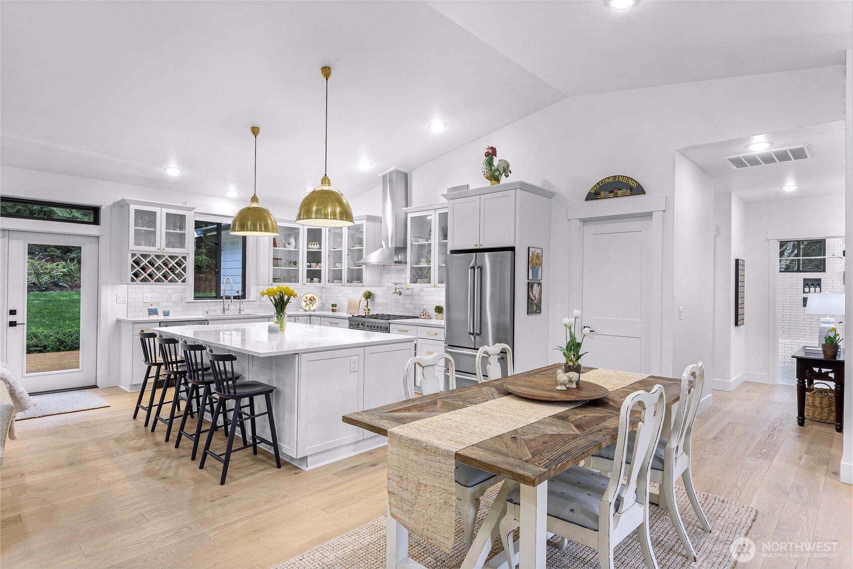 4336 Meander Lane Langley, WA 98260 - Photo 8 of 36 a kitchen with stainless steel appliances kitchen island granite countertop a dining table chairs and white cabinets