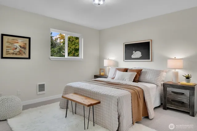 a bedroom with a bed and a lamp on dresser