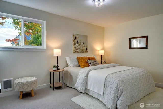 a bedroom with a bed and a painting on the wall