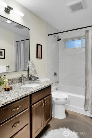 a bathroom with a granite countertop sink toilet and shower