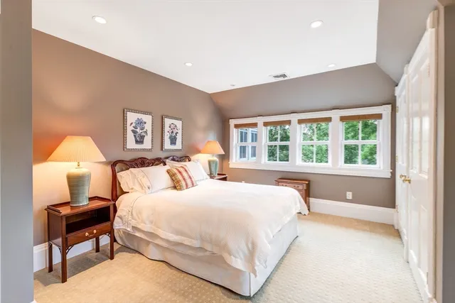a bedroom with a large bed and a lamp on table