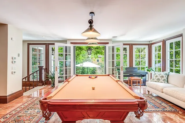 a room with pool table and windows