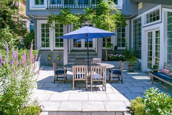 a view of patio with chairs and table with chairs and a small yard