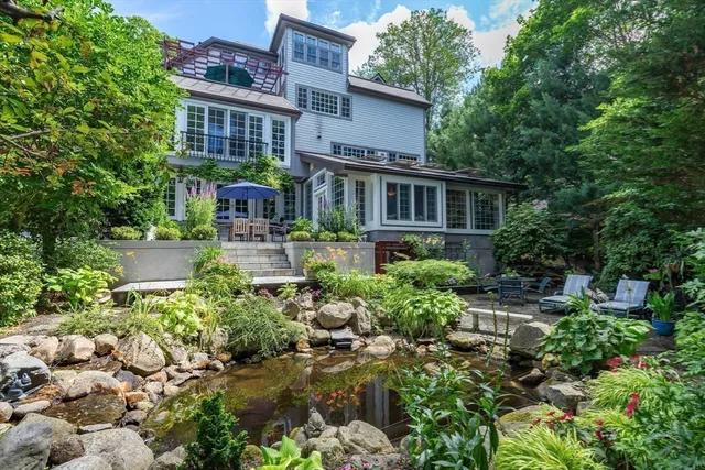 a front view of a house with a yard and potted plants