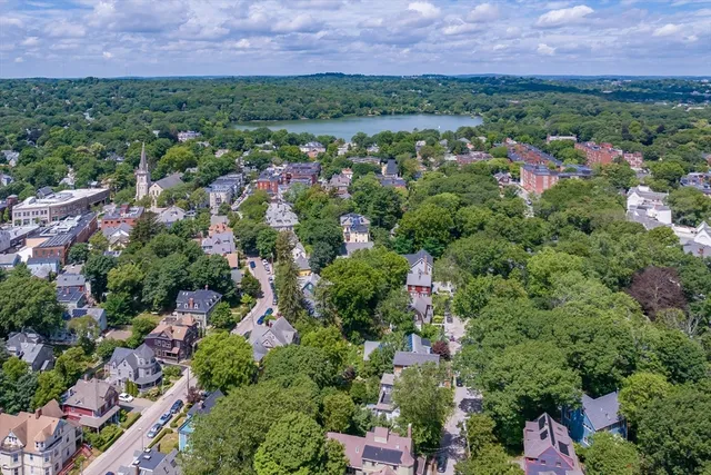 an aerial view of multiple house with outdoor space and trees all around