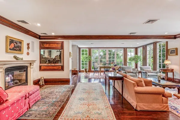 a living room with furniture a fireplace and large windows