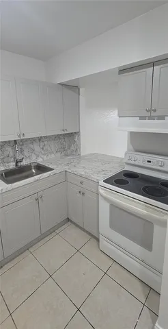 a kitchen with a stove sink and cabinets