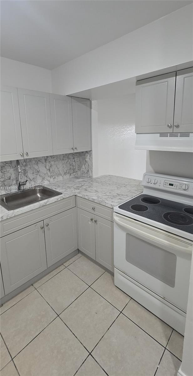 a kitchen with a stove sink and cabinets