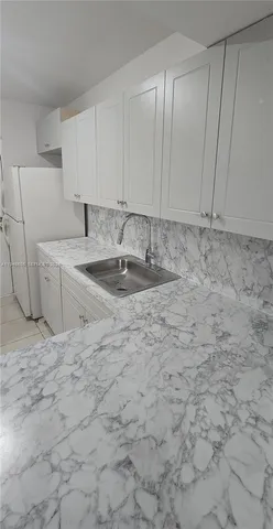 a kitchen with a sink cabinets and a stove