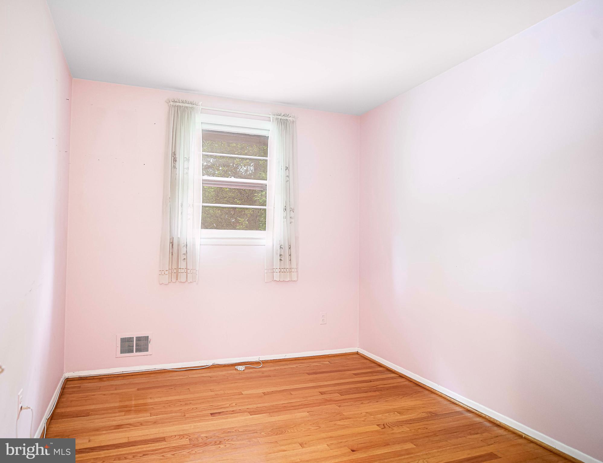 1607 Weyburn Road Rosedale, MD 21237 - Photo 12 of 36 a view of an empty room with wooden floor and a window