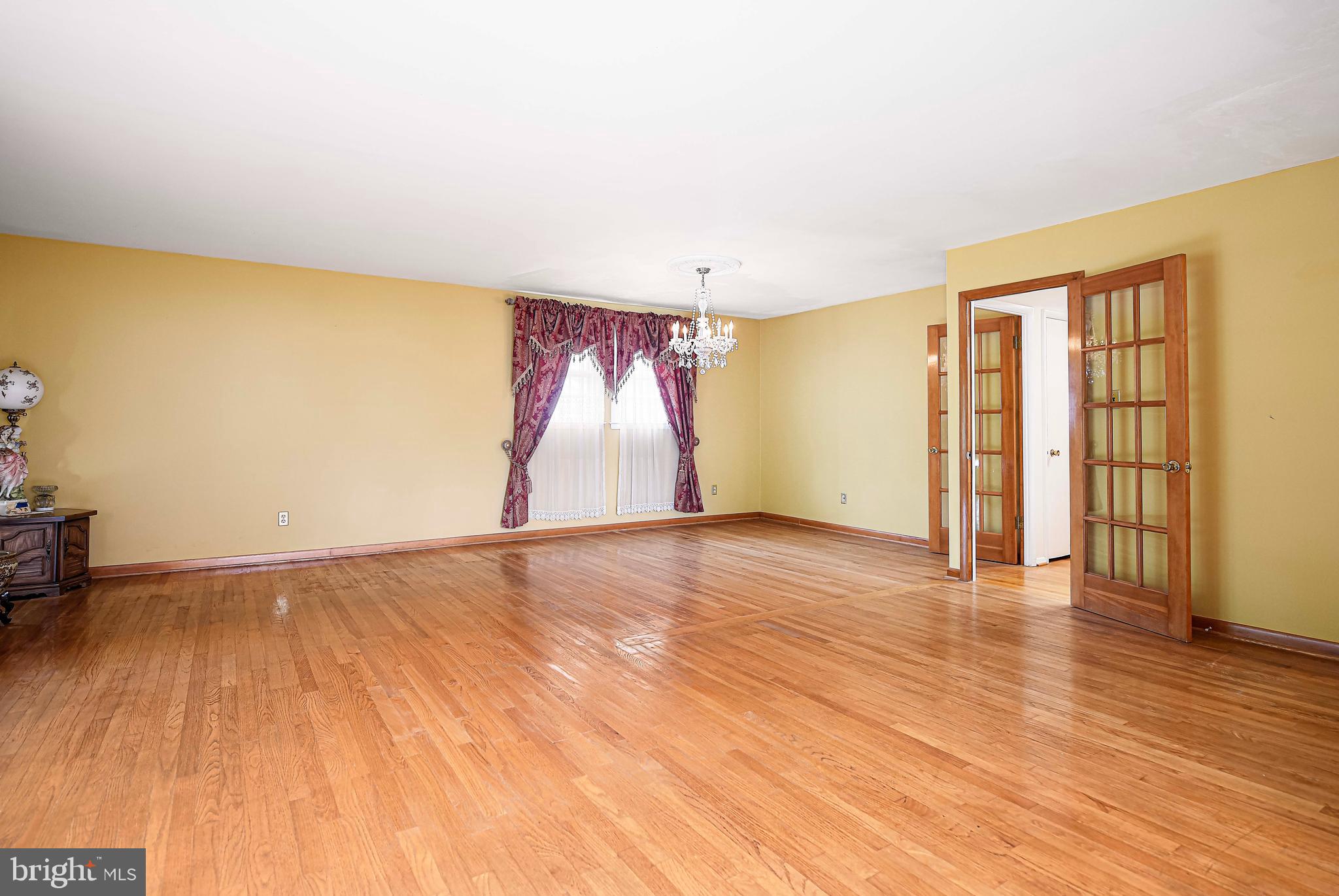 1607 Weyburn Road Rosedale, MD 21237 - Photo 5 of 36 a view of an empty room with wooden floor and a window