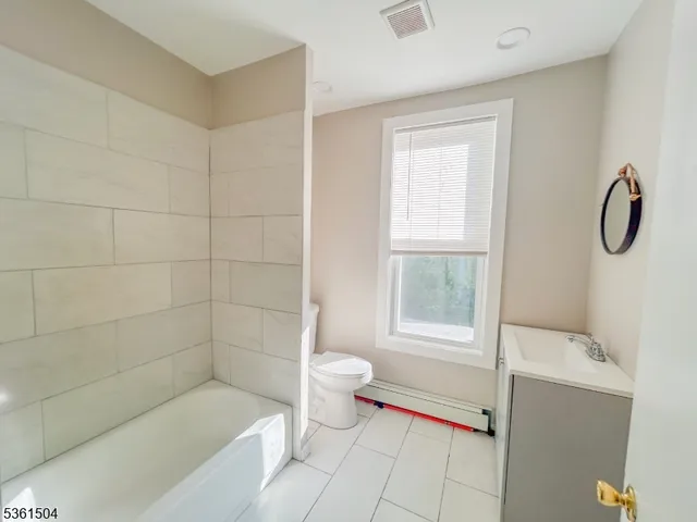 a large bedroom with a bed and wooden floor