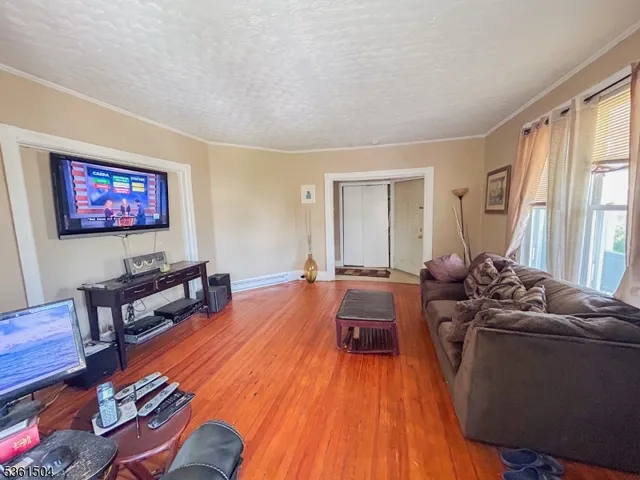 a living room with furniture a flat screen tv and a window
