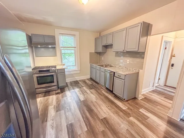a kitchen with stainless steel appliances granite countertop a refrigerator stove and sink