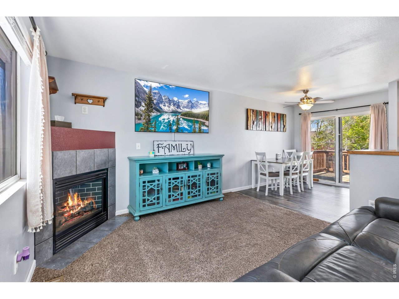 233 East 19th Street Road Greeley, CO 80631 - Photo 5 of 22 a living room with furniture a flat screen tv and a fireplace