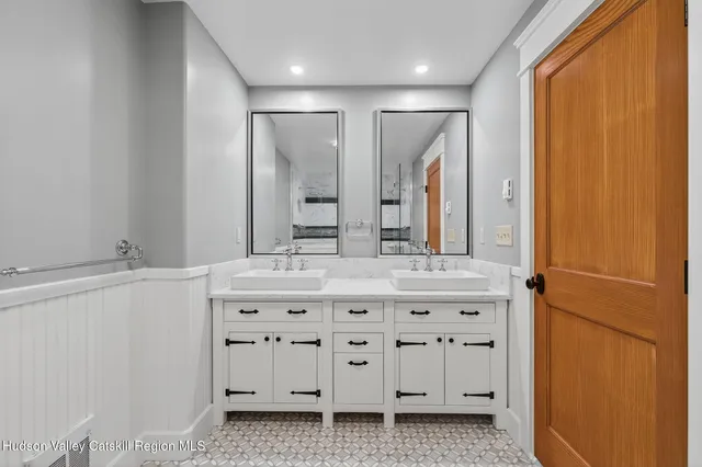 a bathroom with a double vanity sink and mirror