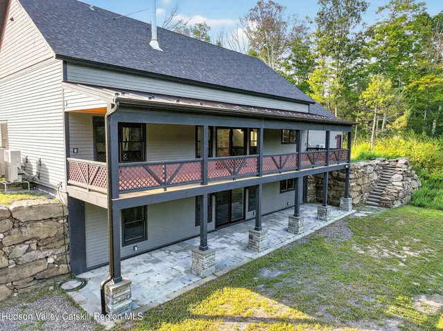 a view of house with a yard and balcony