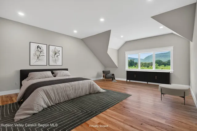 a bedroom with a large bed and a wooden floor