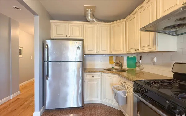 a kitchen with cabinets appliances and wooden floor