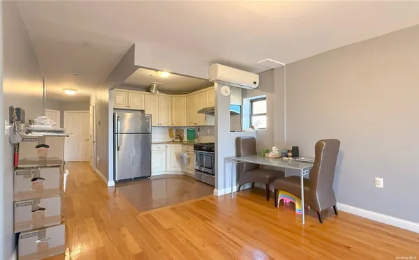 a dining room with furniture a kitchen a chandelier a wooden table and chairs