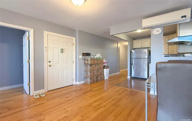 a view of a kitchen with refrigerator and wooden floor