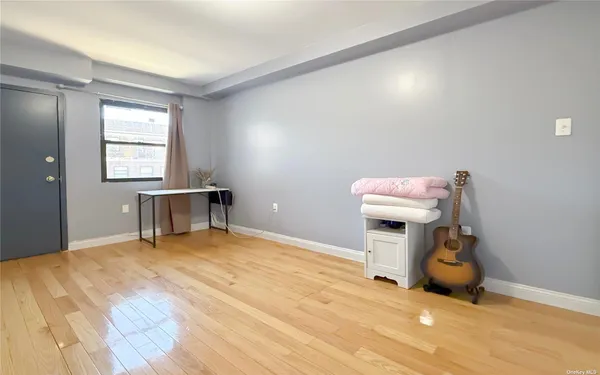 a view of a livingroom with wooden floor and a window