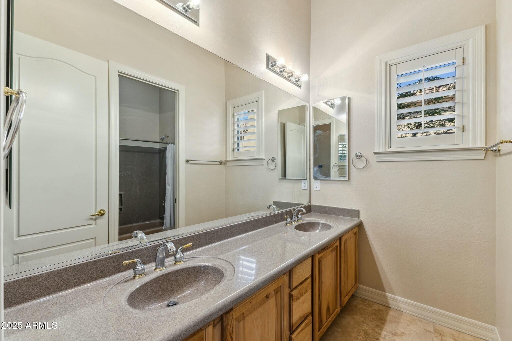 41601 North River Bend Road Anthem, AZ 85086 - Photo 21 of 97 a bathroom with a granite countertop sink and a mirror