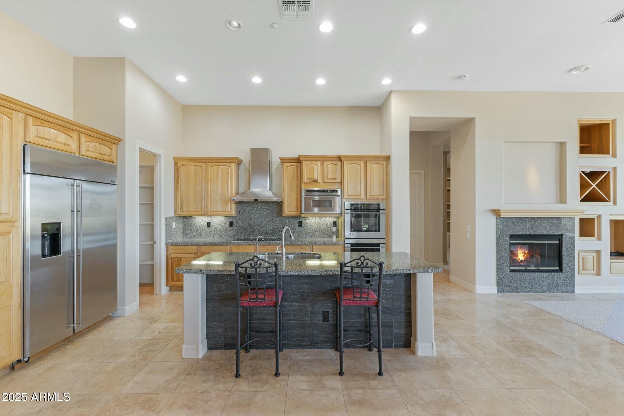 41601 North River Bend Road Anthem, AZ 85086 - Photo 2 of 97 a kitchen with kitchen island granite countertop furniture and a fireplace