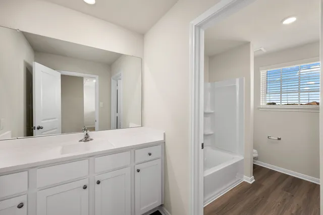 a bathroom with a tub a sink and mirror