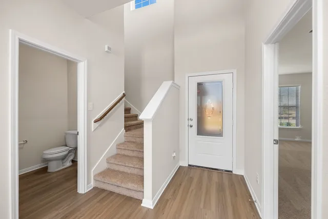 a view of a hallway with wooden floor and staircase