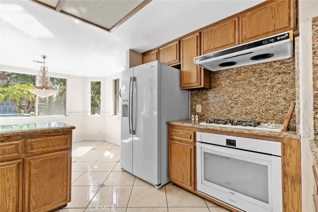 a kitchen with stainless steel appliances granite countertop a refrigerator and a stove