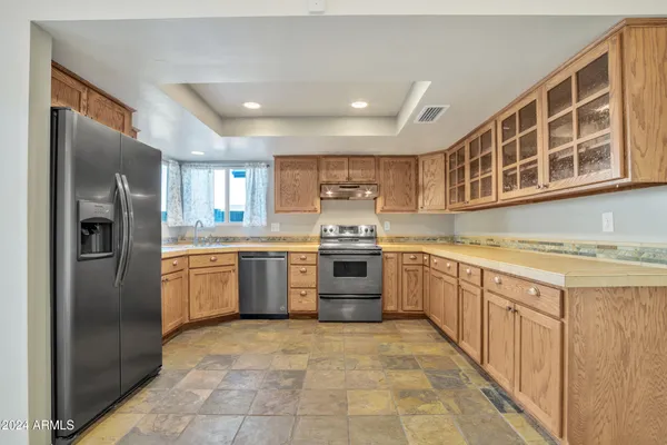 an empty room with wooden floor and ceiling fan