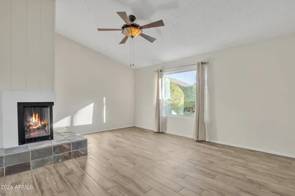 a view of an empty room with window and wooden floor
