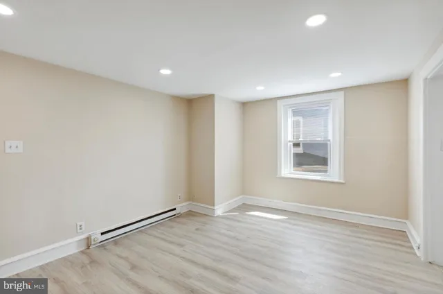 a view of a room with wooden floor and window