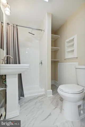 a bathroom with a toilet and a shower