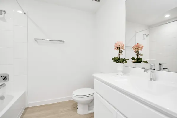 a bathroom with a sink a toilet and shower
