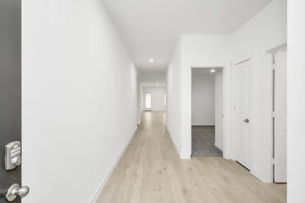 a view of a hallway with wooden floor
