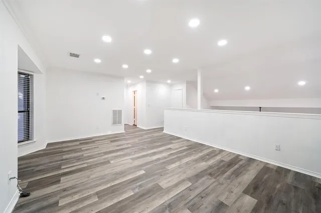 a view of an empty room with wooden floor