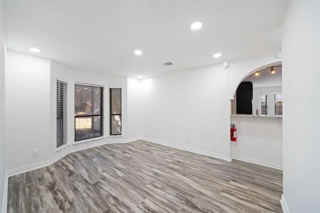 a view of an empty room with wooden floor and entryway