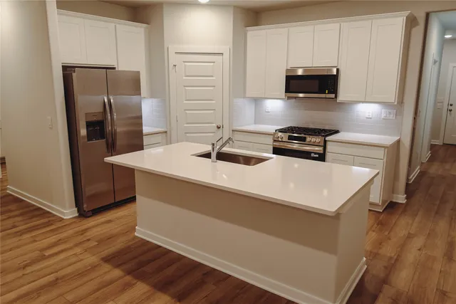 a kitchen with stainless steel appliances a microwave a sink and a refrigerator