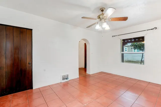 a bedroom with a large bed and a chandelier fan