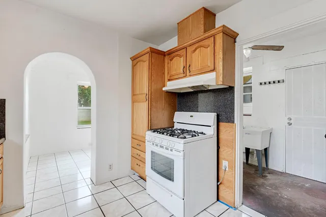 a kitchen with cabinets a stove and a wooden floor