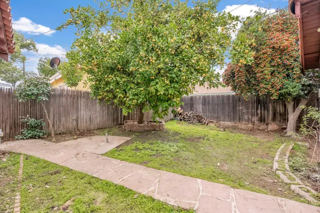 a backyard of a house with trees and wooden fence