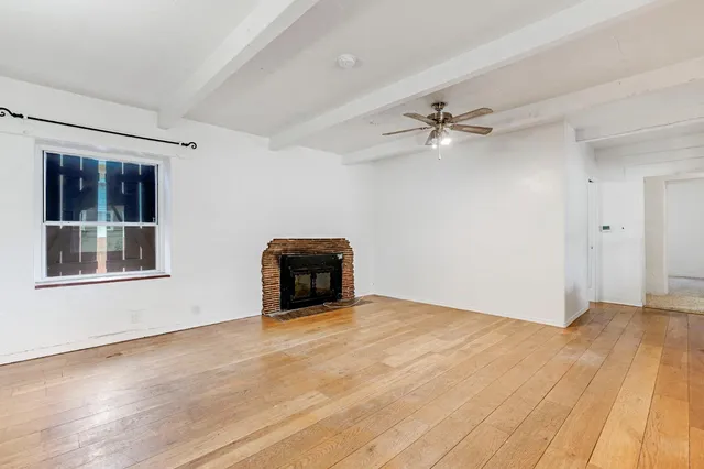 wooden floor in an empty room with a window