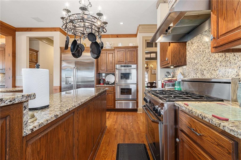 898 Harrison Mill Road Bethlehem, GA 30680 - Photo 40 of 72 a kitchen with granite countertop a stove a sink and a wooden cabinets