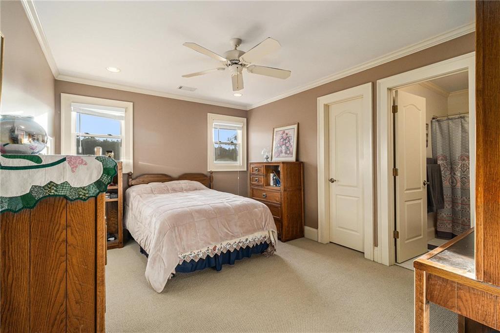 898 Harrison Mill Road Bethlehem, GA 30680 - Photo 62 of 72 a spacious bedroom with a bed and dresser with mirror