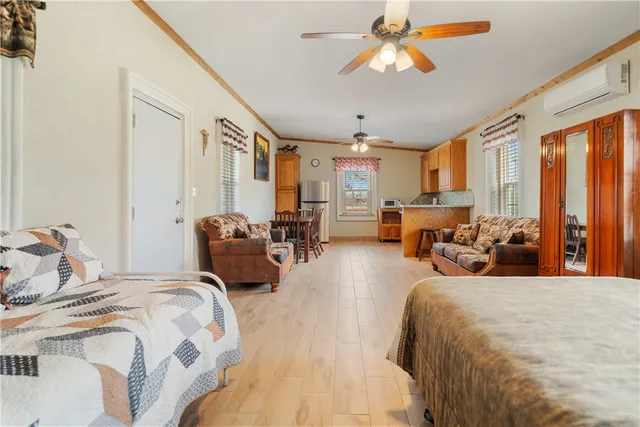 a spacious bedroom with a bed a chandelier and a large window