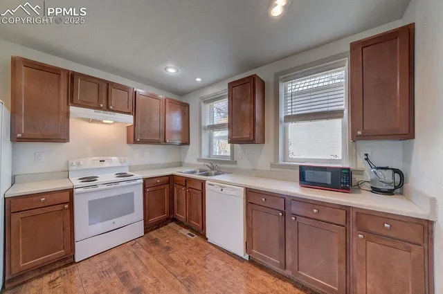 a large kitchen with stainless steel appliances granite countertop a refrigerator and a stove top oven