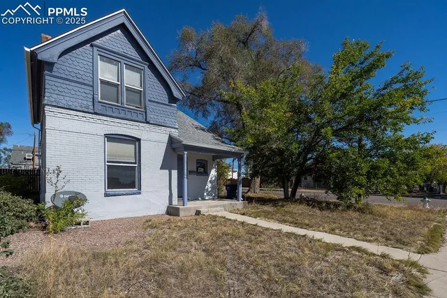 a view of a house with backyard and trees