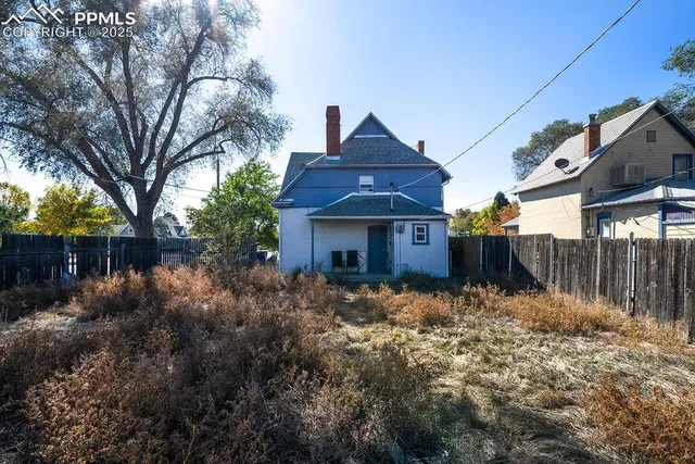a view of a backyard with wooden fence and a bench